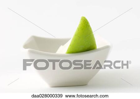 Stock Photo - Apple slice in small dish, close-up. Fotosearch