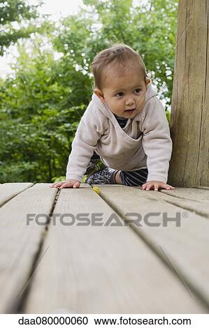 Baby girl crawling on deck View Large Photo Image Stock Image - Baby girl crawling on deck. Fotosearch