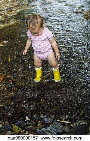 Stock Photo - Baby girl wearing rubber boots, wading in stream. Fotosearch