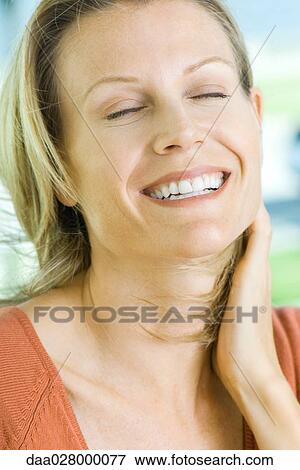 Stock Photo - Blonde woman laughing, eyes closed, portrait. Fotosearch