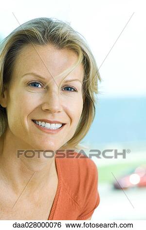 Stock Photograph - Blonde woman smiling at camera, portrait. Fotosearch