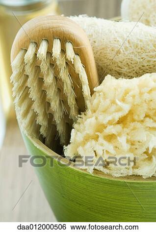 Stock Photograph - Bowl containing bath sponges and brush. Fotosearch