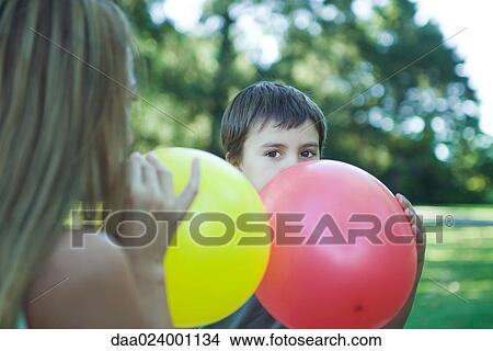 Picture - Boy and mother blowing up balloons. Fotosearch