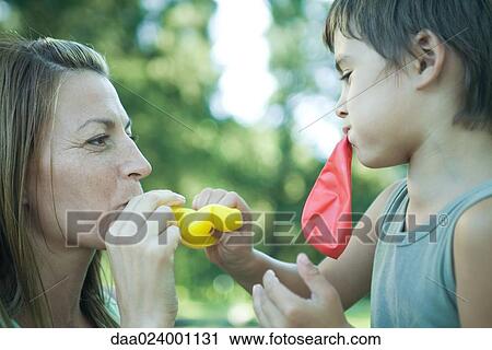 Boy and mother blowing up balloons View Large Photo Image Stock Image - Boy and mother blowing up balloons. Fotosearch