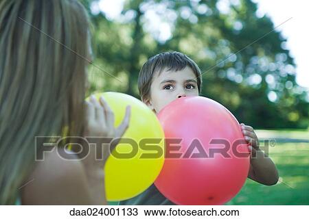 Boy and mother blowing up balloons View Large Photo Image Stock Image - Boy and mother blowing up balloons. Fotosearch