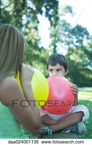 Boy and mother blowing up balloons View Large Photo Image Stock Photography - Boy and mother blowing up balloons. Fotosearch