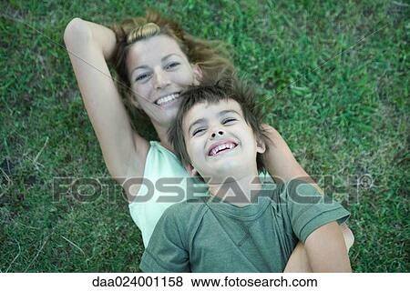 Boy and mother, boy lying on top of woman, on grass, high angle view View Large Photo Image Stock Photo - Boy and mother, boy lying on top of woman, on grass, high angle view. Fotosearch