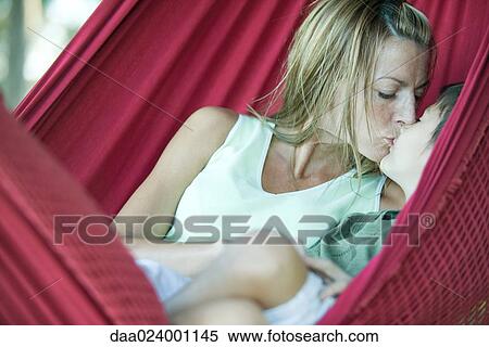 Stock Photography - Boy and mother in hammock, kissing. Fotosearch