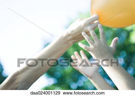 Boy and mother reaching for balloon, cropped view of arms View Large Photo Image Stock Photo - Boy and mother reaching for balloon, cropped view of arms. Fotosearch