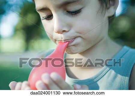 Boy blowing up balloon View Large Photo Image Stock Image - Boy blowing up balloon. Fotosearch