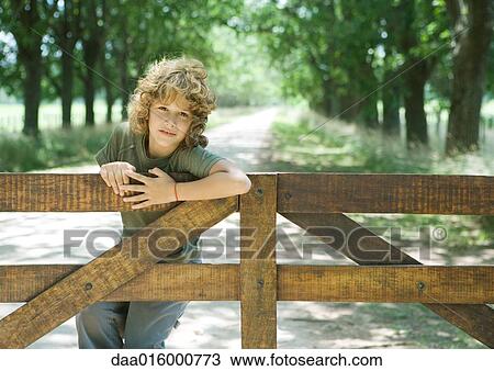 Boy hanging on fence View Large Photo Image Stock Image - Boy hanging on fence. Fotosearch