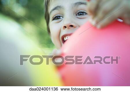 Boy holding balloon, smiling, looking away View Large Photo Image Stock Photograph - Boy holding balloon, smiling, looking away. Fotosearch