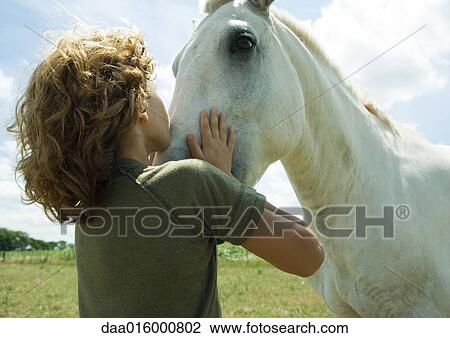 Boy kissing horse View Large Photo Image Stock Image - Boy kissing horse. Fotosearch