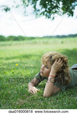 Stock Photo - Boy lying in grass. Fotosearch