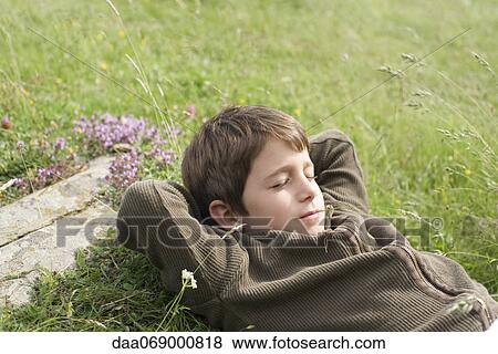 Stock Photo - Boy napping on grass. Fotosearch