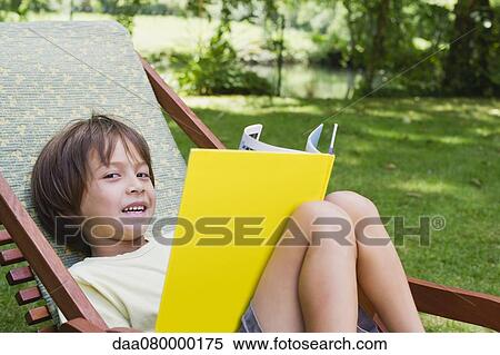 Boy reclining in deckchair with book View Large Photo Image Stock Photography - Boy reclining in deckchair with book. Fotosearch