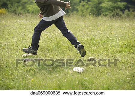 Stock Photography - Boy running in field, low section. Fotosearch