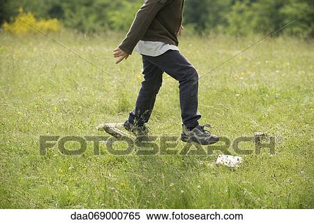 Stock Photography - Boy running in field, low section. Fotosearch