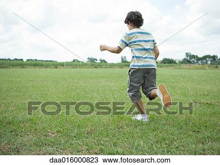 Stock Image - Boy running in field. Fotosearch