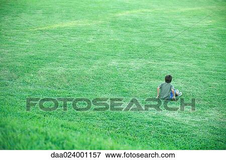 Boy sitting in grass, high angle view, full length View Large Photo Image Stock Photo - Boy sitting in grass, high angle view, full length. Fotosearch