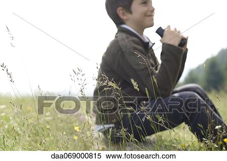 Boy sitting in tall grass View Large Photo Image Stock Photography - Boy sitting in tall grass. Fotosearch