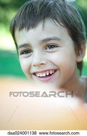 Boy smiling, balloon in blurred foreground, portrait View Large Photo Image Stock Photo - Boy smiling, balloon in blurred foreground, portrait. Fotosearch