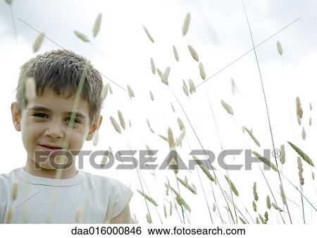 Stock Photograph - Boy standing in weeds. Fotosearch