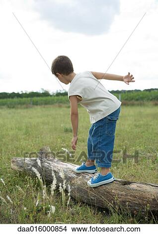 Picture - Boy standing on log. Fotosearch