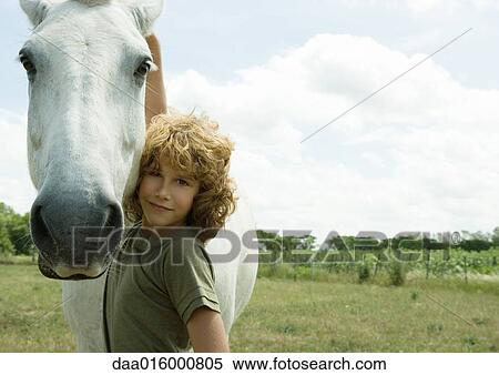 Boy standing with arm around horse View Large Photo Image Stock Photography - Boy standing with arm around horse. Fotosearch