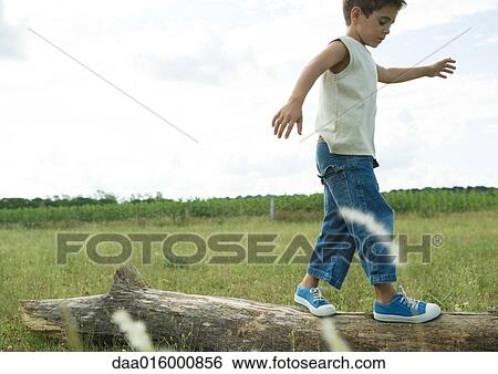 Stock Photograph - Boy walking on log. Fotosearch