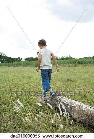 Stock Photography - Boy walking on log. Fotosearch
