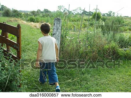 Stock Photo - Boy walking through gate. Fotosearch