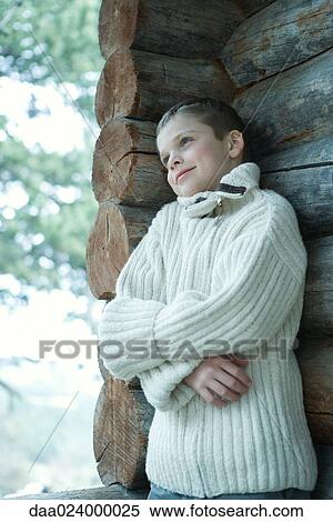 Boy wearing wool sweater, arms folded, leaning against log cabin View Large Photo Image Stock Photography - Boy wearing wool sweater, arms folded, leaning against log cabin. Fotosearch