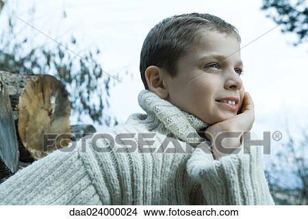Boy wearing wool sweater, hand under chin, looking away View Large Photo Image Picture - Boy wearing wool sweater, hand under chin, looking away. Fotosearch