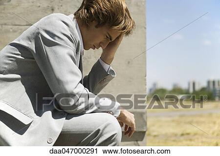 Businessman contemplatively holding head View Large Photo Image Stock Image - Businessman contemplatively holding head. Fotosearch