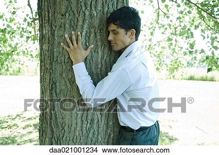 Businessman hugging tree View Large Photo Image Picture - Businessman hugging tree. Fotosearch