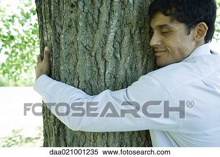 Businessman hugging tree View Large Photo Image Stock Photography - Businessman hugging tree. Fotosearch