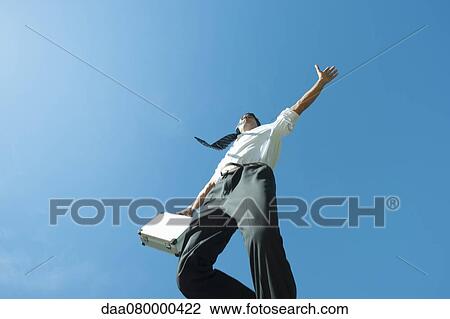 Businessman jumping in air carrying briefcase, low angle view View Large Photo Image Stock Image - Businessman jumping in air carrying briefcase, low angle view. Fotosearch