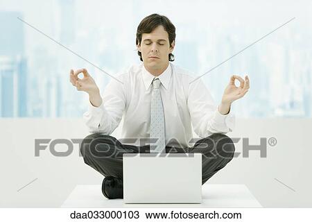 Businessman meditating in office, eyes closed View Large Photo Image Stock Image - Businessman meditating in office, eyes closed. Fotosearch