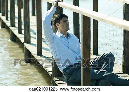 Businessman on wooden footbridge over lake, looking away View Large Photo Image Stock Photography - Businessman on wooden footbridge over lake, looking away. Fotosearch