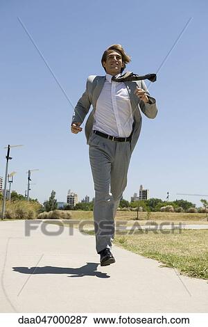Businessman running down sidewalk with look of determination View Large Photo Image Stock Photo - Businessman running down sidewalk with look of determination. Fotosearch