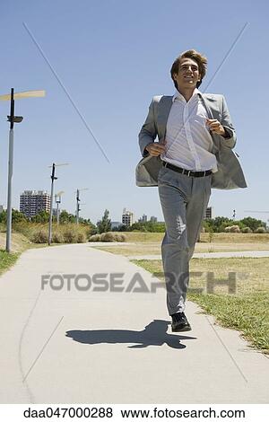 Businessman running down sidewalk with look of optimism View Large Photo Image Stock Photo - Businessman running down sidewalk with look of optimism. Fotosearch