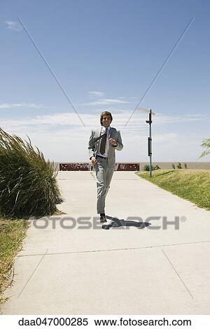 Businessman running down sidewalk with expression of decisiveness View Large Photo Image Stock Photography - Businessman running down sidewalk with expression of decisiveness. Fotosearch