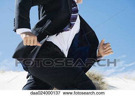 Businessman running, sand dune in background, cropped view of mid section View Large Photo Image Stock Photo - Businessman running, sand dune in background, cropped view of mid section. Fotosearch