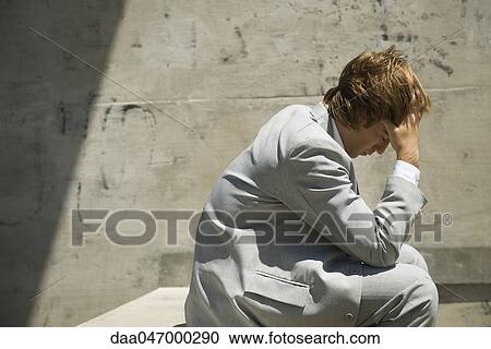 Businessman sitting holding head View Large Photo Image Stock Image - Businessman sitting holding head. Fotosearch