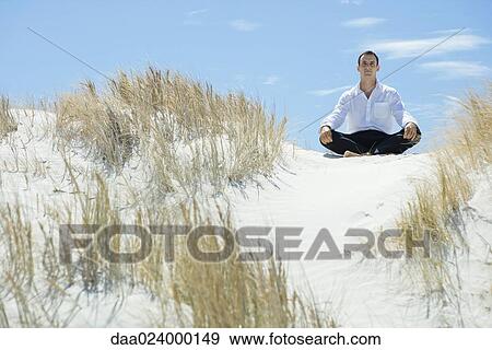 Businessman sitting on sand dune, indian style View Large Photo Image Stock Photo - Businessman sitting on sand dune, indian style. Fotosearch