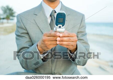 Businessman using cell phone outdoors, cropped view View Large Photo Image Stock Photography - Businessman using cell phone outdoors, cropped view. Fotosearch