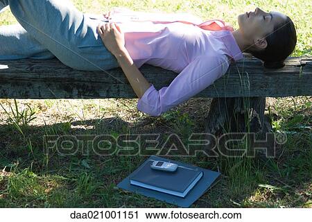 Businesswoman lying on bench, outdoors View Large Photo Image Stock Image - Businesswoman lying on bench, outdoors. Fotosearch