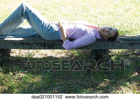Businesswoman lying on bench, outdoors View Large Photo Image Stock Image - Businesswoman lying on bench, outdoors. Fotosearch