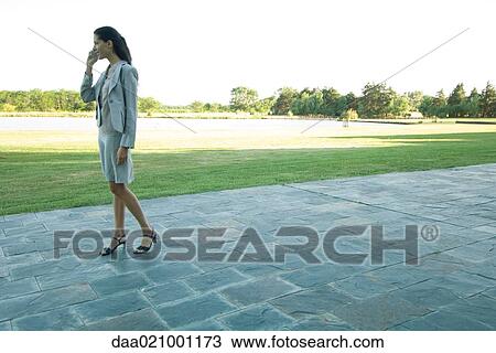 Businesswoman standing on patio, using cell phone View Large Photo Image Stock Image - Businesswoman standing on patio, using cell phone. Fotosearch